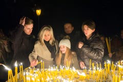 Um die Toten und die Lebenden zu ehren zündet Familie Nedic vor dem Betreten der Kirche Kerzen an. (Bild: Ralph Ribi)