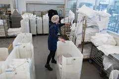 Eine Mitarbeiterin sortiert die Kissen und Decken für die Passagiere. (Bild: Ralph Ribi)