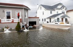 In Lindenhurst treibt ein Boot in einer Hausauffahrt. (Bild: Keystone)