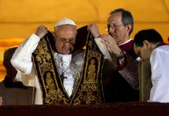 Papst Franziskus zieht die Schärpe an. (Bild: Keystone)
