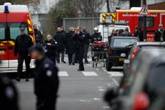 Polizisten und Feuerwehrleute beim Tatort. (Bild: Keystone)
