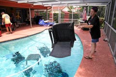 Jackie Kreuter aus Gulfport in Florida, wähnt ihre Gartenmöbel im Pool vor dem Sturm in Sicherheit. (Bild: Keystone)