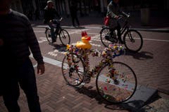 Eine Ente mit Krone sitzt auf einem Velo, das mit Dutzenden Plastikenten dekoriert ist. (Bild: Keystone)