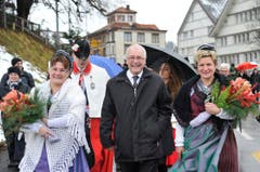 Ein gut gelaunter Hans Altherr auf dem Weg zum Trogener Dorfplatz, flankiert von Trachtenfrauen. (Bild: Keystone)