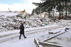 Eine Frau geht an Trümmern vorbei. (Bild: EPA/Emiliano Grillotti)