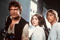 Star Wars ist die kommerziell erfolgreichste Filmserie der Geschichte. Allein bis 2012 wurden inklusive der Kinotickets geschätzte 24 Milliarden Euro eingenommen. Im Bild die drei Hauptdarsteller der ersten drei Teile (v.l.): Harisson Ford als Han Solo, Carrie Fisher als Prinzessin Leia und Mark Hamill als Luke Skywalker. (Bild: Keystone)