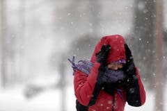 Eine Frau versucht sich in St.Louis gegen den Schnee zu schützen. (Bild: Keystone)