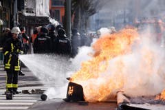 Ein Feuerwehrmann löscht brennende Blockaden. (Bild: Keystone)