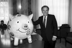 Der Finanzminister Otto Stich mit einem selbstgebastelten, rosa Sparschwein, das er von Auslandschweizerkinder 1994 geschenkt bekam. (Bild: Keystone)