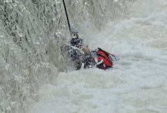 Ein Polizeitaucher wird zum Fuss des Wasserfalls gezogen. (Bild: Reto Martin)