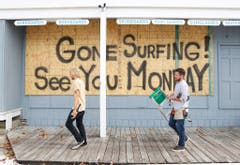 Nun hat der Tropensturm Kurs in Richtung USA genommen. In Ocean City machen zwei Surfshop-Besitzer ihren Laden dicht. (Bild: Keystone)