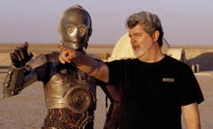 George Lucas hat als Drehbuchautor auch mehr Geld eingespielt als jeder andere. Rund 3 Milliarden Dollar gaben Kinozuschauer bisher aus, um seine Filme zu sehen. Im Bild mit Roboter C-3PO während den Dreharbeiten zu "Star Wars II: Attack of the Clones". (Bild: LISA TOMASETTI (AP LUCASFILM))