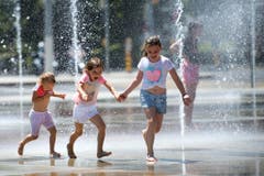 Beliebter Sommerplausch für Kinder: Abkühlen bei Wasserfontänen, hier in Genf. (Bild: MARTIAL TREZZINI (KEYSTONE))