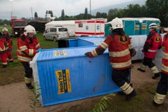 Helfer stellen ein umgekipptes mobiles WC wieder auf. (Bild: Keystone)
