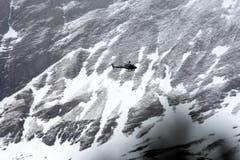 Ein Rettungshelikopter im Einsatz über dem Absturzgebiet. (Bild: Keystone)