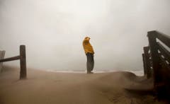 In Virginia Beach trotzt ein Spaziergänger den starken Winden. (Bild: Keystone)