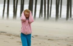 Sturmwinde peitschen der neunjährigen Molly White am Strand von Frankford um die Ohren. (Bild: Keystone)