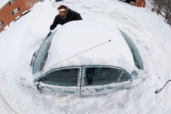 Eine Frau buddelt ihr Auto aus. (Bild: Keystone)