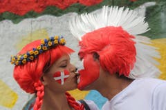 Blumenmädchen und Irokesenmann: Ein Küsschen auf die Schweiz. (Bild: Keystone)
