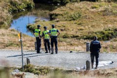 Polizisten und Forensiker stehen in der Nähe der Absturzstelle. (Bild: Keystone)