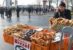 Ein Mann verkauft seine Brezeln inmitten der Demonstranten. (Bild: Keystone)