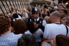 Ein Polizist versucht die Menge vor dem Buckingham Palace unter Kontrolle zu halten. (Bild: Keystone)