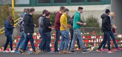 Vor der Schule der verunglückten Klasse werden zahlreiche Kerzen niedergelegt. (Bild: Keystone)