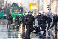 Polizisten jagen Demonstranten, welche das EZB-Hauptgebäude blockieren wollen. (Bild: Keystone)