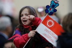 Ein Mädchen hält eine Fähnchen in den Landesfarben in der Hand. (Bild: Keystone)