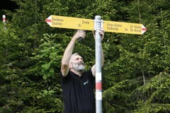 Die Wegweiser sind an der Spitze rot-weiss bemalt. Auch die Eisenstange trägt diese Markierung. Das bedeutet, dass es sich hierbei um einen Bergweg handelt. (Bild: Jolanda Riedener)
