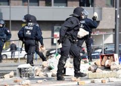 Polizisten räumen Steine weg, welche Demonstranten geworfen haben. (Bild: Keystone)