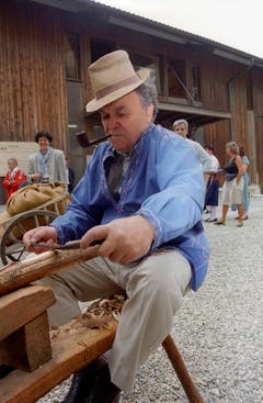 Bundesrat Otto Stich bearbeitet im Juli 1995 in Wolhusen (Luzern) während des Ausflugs des Bundesrats ein Stück Holz. (Bild: Keystone)