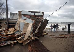 Menschen begutachten die Schäden nach dem Sturm. (Bild: Keystone)