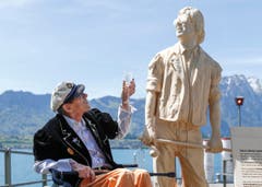 Der Schweizer Musiker Polo Hofer posiert neben seinem Denkmal im Hafen in Oberhofen am Thunersee. Die Statue wurde vom Künstler Inigo Gheyselinck aus einer Weisstanne aus Polo Hofers Heimatort Interlaken hergestellt. Sie wird später auf dem Schiff «Blüemlisalp» montiert. (Bild: Peter Klaunzer, Keystone)