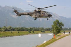 Der Rheindamm wird bei Ruggell mit grossen Sandsäcken verstärkt, und Löcher werden gestopft. (Bild: Christoph Krapf)