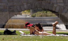 Zwei Touristinnen beim Sonnenbaden in einem Park in Spaniens Hauptstadt Madrid. (Bild: MARISCAL (EPA EFE))