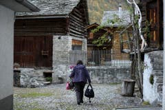 Eine Dorfbewohnerin auf dem Weg in ihr Zuhause. (Bild: KEYSTONE/Gian Ehrenzeller)