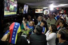 Menschen versammeln sich vor dem Fernseher in einem Restaurant in Doral (Florida). (Bild: Keystone)