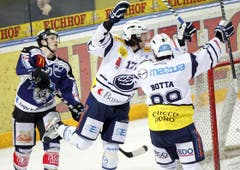 Joel Perrault, Mitte, und Roman Botta, rechts, von Ambri feiern ein Tor vor Dominic Lammer.