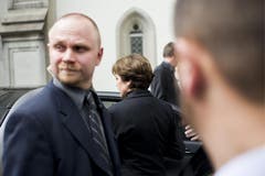 Witwe Paola Felix steigt hinter den Sicherheitsbeamten ins Auto. (Bild: Keystone)