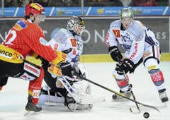 Gaetan Haas vom EHC Biel kämpft mit Zugs Goalie Jussi Markkanen und Yannick Blaser um die Scheibe. (Bild: Keystone)
