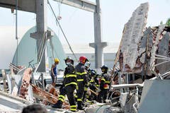 Feuerwehrleute suchen in einer kollabierten Fabrik in Mirandola nach Opfern. (Bild: Keystone / AP)