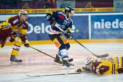 Die Genfer Christian Marti, links, und Daniel Vukovic im Kampf um den Puck gegen Robin Grossmann vom EVZ. (Bild: SIGI TISCHLER)