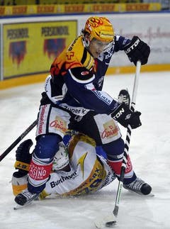Damien Brunner vom EV Zug, oben, überfährt Jan von Arx vom HC Davos. (Bild: Keystone)