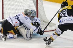 Die Zuger Samuel Erni, links, und Tobias Stephan sichern vor Luganos Brett McLean den Puck. (Bild: CARLO REGUZZI)