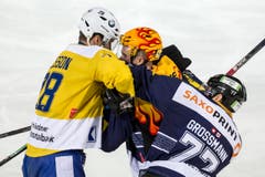 Der Davoser Stuermer Dick Axelsson, links, im Spiel gegen den Zuger Stuermer Pierre-Marc Bouchard, Mitte, und den Zuger Verteidiger Robin Grossmann. (Bild: Keystone)