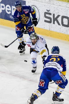 Zugs Dominik Schlumpf (mitte) gegen die Davoser Dario Simion (oben) und Mauro Jörg. (Bild: Keystone)