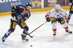 Der Zuger Stuermer Josh Holden (links) Spielt den Puck während der Bieler Stürmer Mathieu Tschantre ihn daran hindern will. (Bild: Alexandra Wey / Keystone)