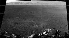 Das sind die ersten zwei hochaufgelösten Bilder der Marsoberfläche, die von den Navigationskameras auf dem Mast des Mars-Rovers «Curiosity» aufgenommen wurden. Am Horizont lässt sich der Rand des Kraters «Gale» erkennen, in dem der Rover gelandet war. Die Einbuchtungen unmittelbar vor dem Rover rühren von den Raketendüsen des Landekrans. (Bild: Nasa / JPL-Caltech)