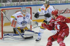 Sie alle haben den Puck im Blick: Der Zuger Torhüter Tobias Stephan und der Zuger Spieler Yannick Blaser und der Lausanner Eric Walsky (rechts). (Bild: Keystone / Jean-Christophe Bott)